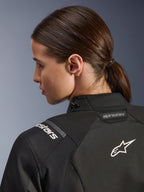 Veste Femme Alpinestars Stella Andes V4 Drystar®, noire, vue rapprochée du haut du dos et de l'épaule, avec logo Astar et marquage blancs brodés, construction en textile technique pour l'aventure à moto