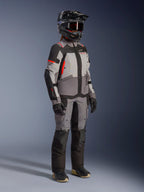 Alpinestars Stella Andes V4 Drystar®, veste de moto touring femme, grise et noire avec corail fluo, portée par une motarde.
