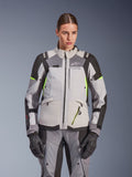 Veste Alpinestars Stella Andes V4 Drystar® pour femme, gris glacé et gris foncé avec accents jaune fluo, veste de moto d'aventure touring, portée avec pantalon et gants assortis, construction textile protectrice et logo Alpinestars