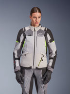 Veste Alpinestars Stella Andes V4 Drystar® pour femme, gris glacé et gris foncé avec accents jaune fluo, veste de moto d'aventure touring, portée avec pantalon et gants assortis, construction textile protectrice et logo Alpinestars