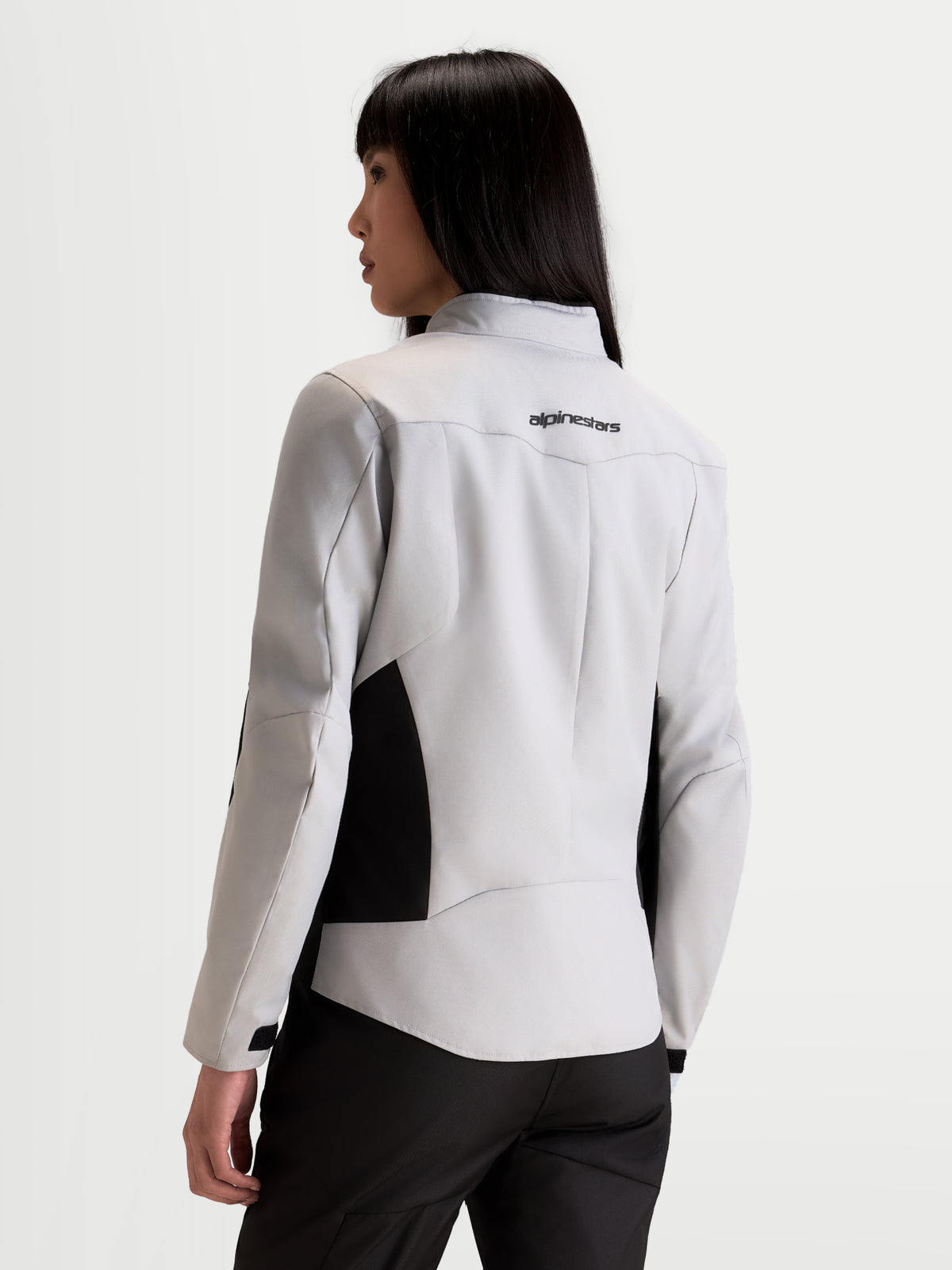 Alpinestars Stella C 1 Waterproof Veste, veste de moto urbaine pour femme en gris glace et noir, vue de dos sur un modèle montrant la construction du haut du dos et le logo de la marque