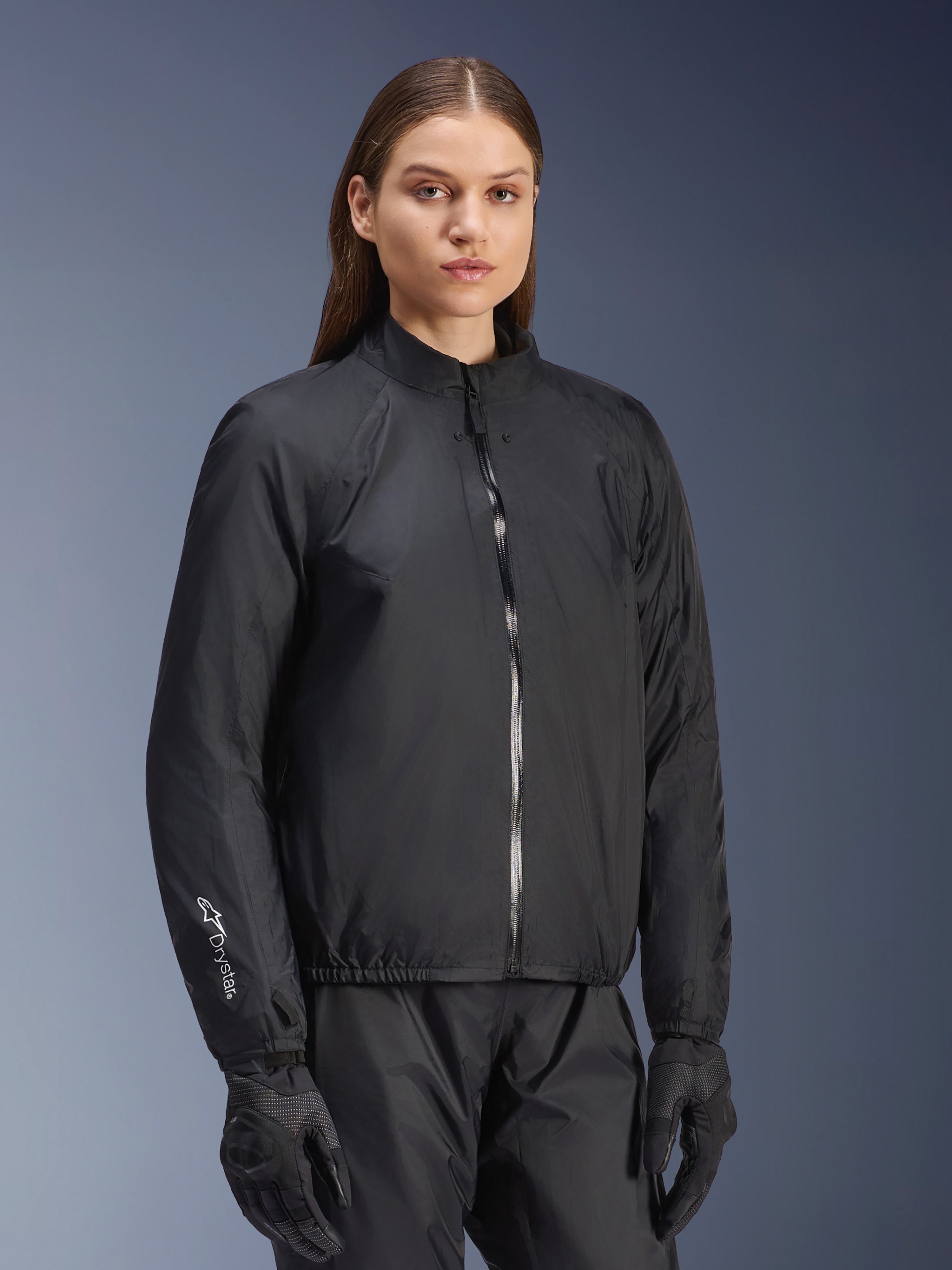 Veste Alpinestars Stella Andes Air Drystar®, veste de moto pour femme, noire, présentant la membrane imperméable amovible avec fermeture éclair intégrale et logo Drystar sur la manche, portée avec un pantalon et des gants de moto noirs assortis