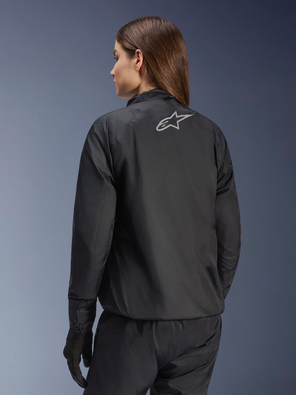 Veste Alpinestars Stella Andes Air Drystar®, veste de moto pour femme, noire, vue arrière montrant le logo étoile argenté, associée à un pantalon et des gants noirs, équipement de touring imperméable léger