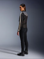 Mannequin femme vue de profil et de dos portant la veste Alpinestars Stella T-Dyno WR en Noir Gris Foncé Écru, au design d'inspiration vintage avec des bandes écrues sur les manches et un empiècement gris dans le dos, portée avec un pantalon noir et des chaussures de moto noires.