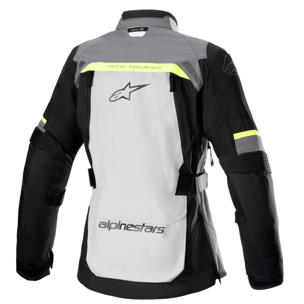 Veste Alpinestars Stella Bogota' Pro Drystar® pour femme, vue arrière, gris glace et gris foncé avec des touches de jaune fluorescent, dotée d'un grand logo au dos, du texte « Tech Touring », de zips de ventilation verticaux et de panneaux en accordéon renforcés aux coudes.
