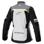 Veste Alpinestars Stella Bogota' Pro Drystar® pour femme, vue arrière, gris glace et gris foncé avec des touches de jaune fluorescent, dotée d'un grand logo au dos, du texte « Tech Touring », de zips de ventilation verticaux et de panneaux en accordéon renforcés aux coudes.