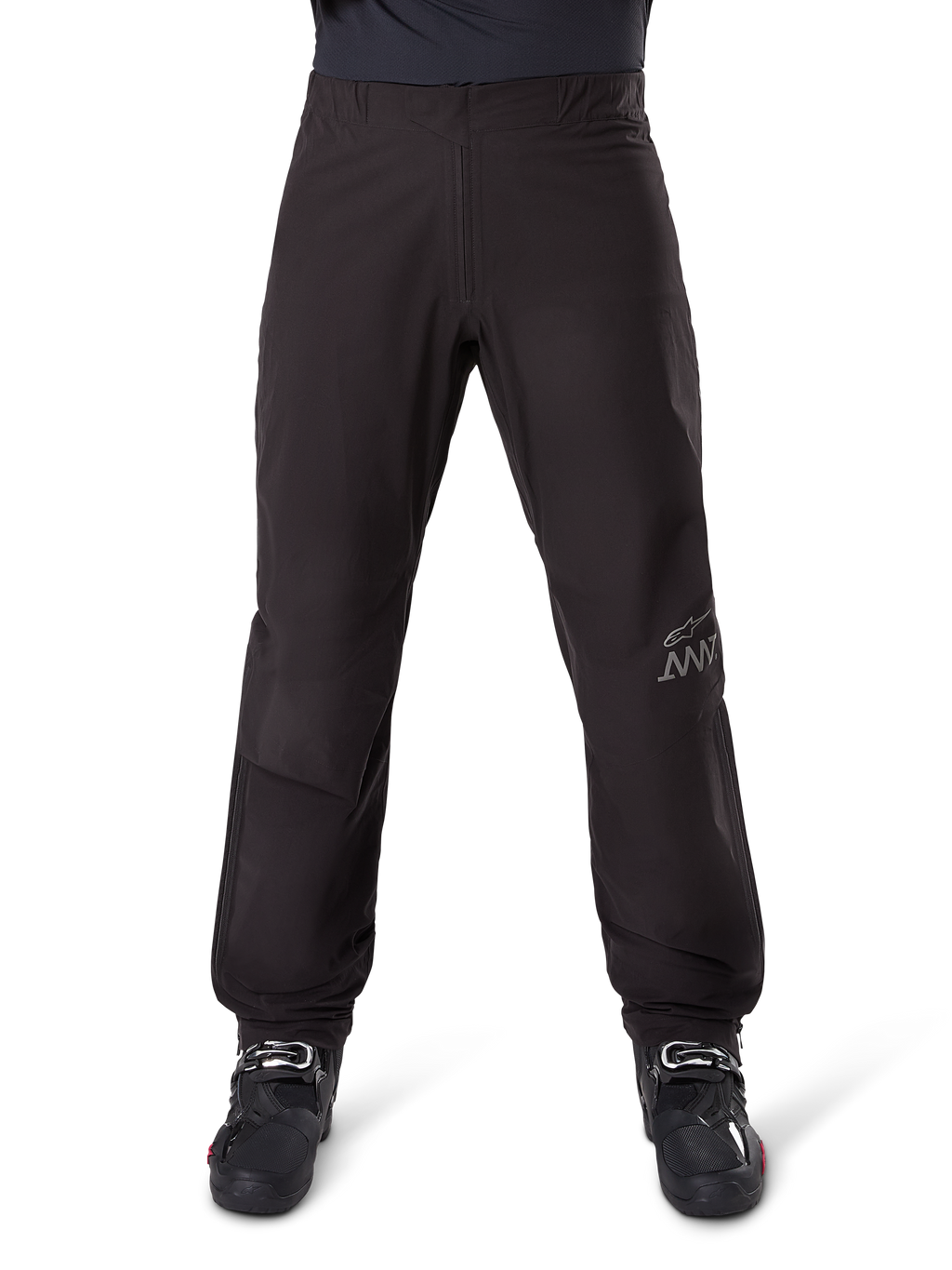 Doublure de pantalon Alpinestars AMT-8 Stretch Drystar® XF, noire, vue de face portée avec des bottes de moto noires, arborant le logo étoile gris et le marquage AMT sur la jambe, vêtement de moto polyvalent imperméable et coupe-vent