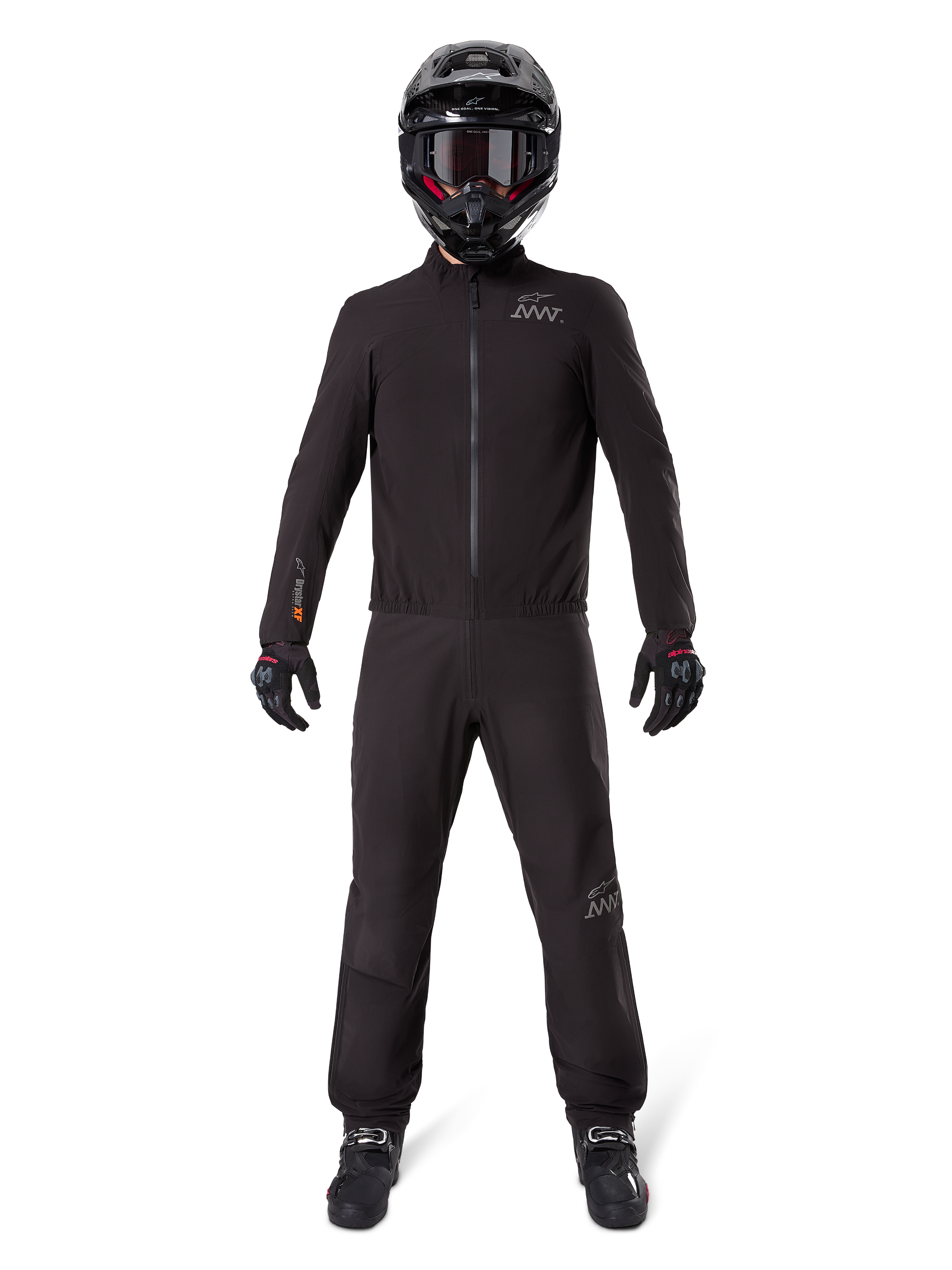 Pilote de moto portant la doublure de pantalon Alpinestars AMT-8 Stretch Drystar® XF et la veste assortie, équipement technique noir imperméable et coupe-vent, avec casque, gants et bottes noirs, design adventure touring épuré.