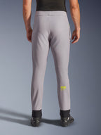 Pantalon Alpinestars Aeroshell, pantalon de moto, gris moyen et jaune fluo, vue arrière montrant le logo Astars jaune sur le mollet, chevilles élastiques noires, design moderne en textile softshell pour la route et un usage décontracté.