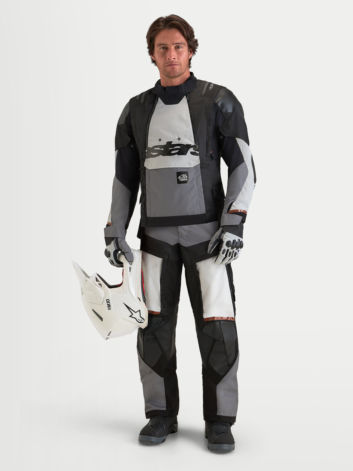 Alpinestars Harok V2 Drystar Pants, Men's adventure motorcycle pants in dark gray, ice gray, and black, worn on model with matching ADV jacket and holding a white helmet, CE certified all-terrain riding gear