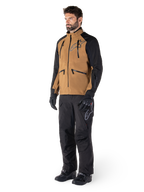 Pantalon Alpinestars Hyde XT Drystar®, pantalon de moto aventure, noir, porté avec une veste technique marron et noire, des gants et bottes noirs, doté d'une conception par-dessus la botte pour la conduite tout-terrain et dual-sport
