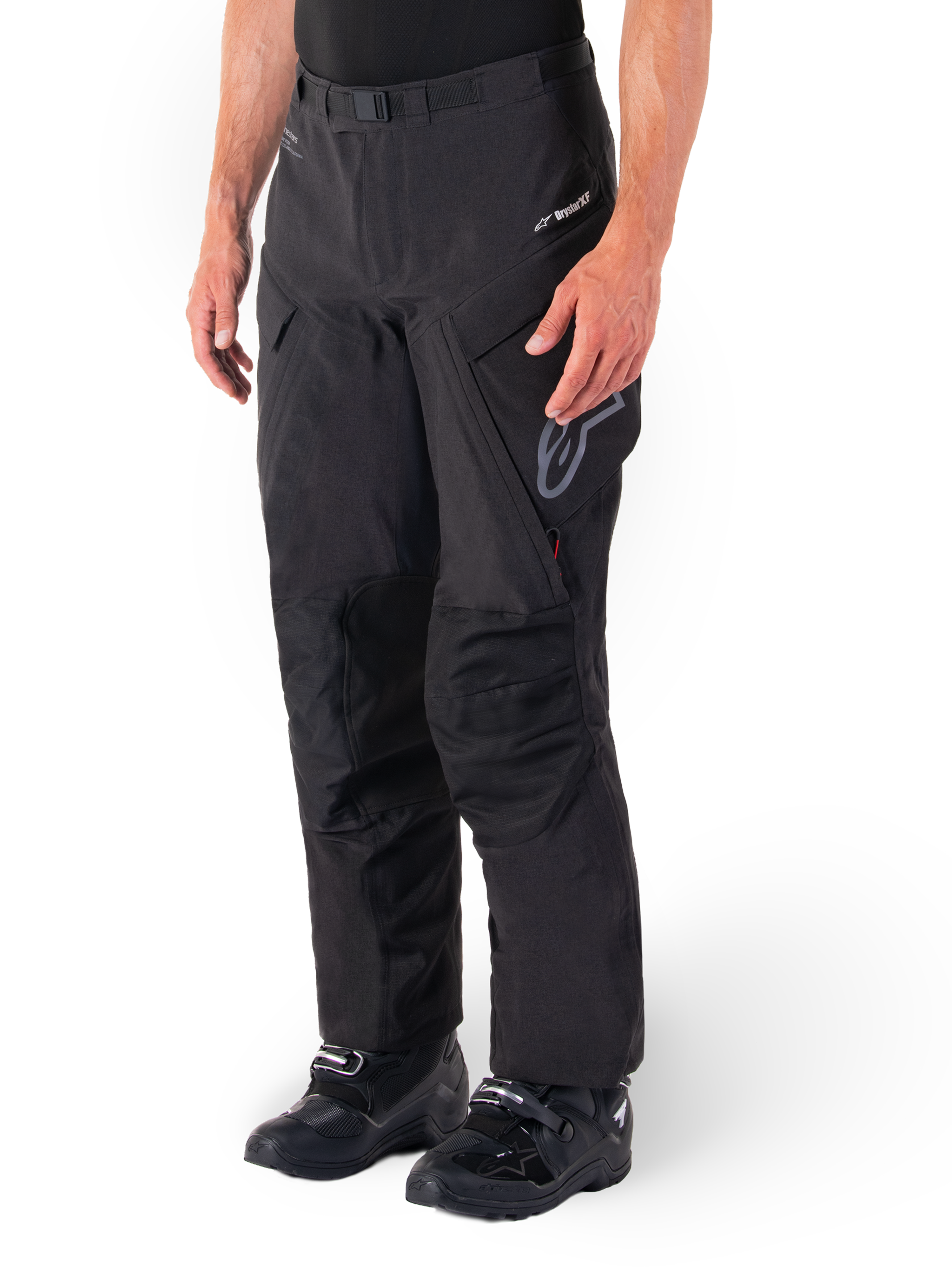 Pantalon Alpinestars Hyde XT Drystar®, pantalon de moto tourisme d'aventure, noir, porté avec des bottes noires, arborant le logo de la membrane laminée Drystar®XF, des panneaux de genoux renforcés et des poches cargo zippées.