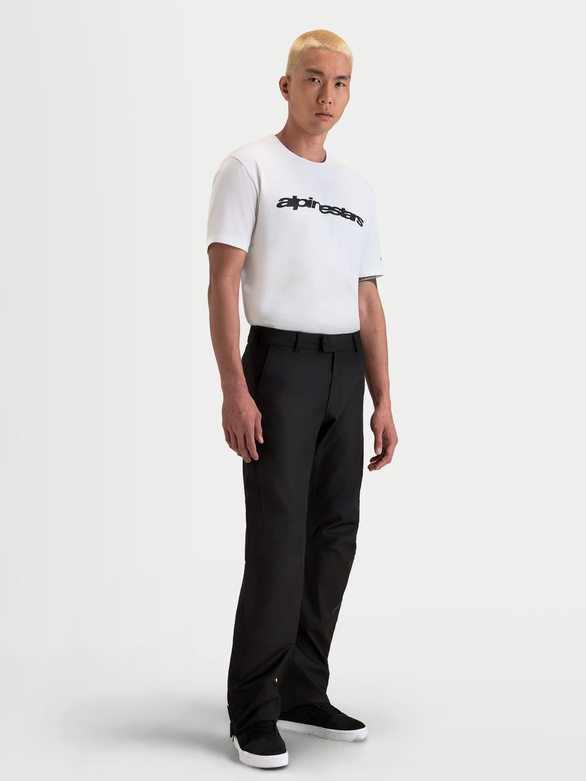 Alpinestars C 1 Waterproof Pantalons, pantalon de moto imperméable pour homme noir, coupe droite, porté par un modèle avec un t-shirt blanc