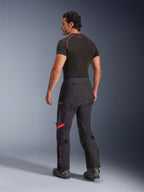 Alpinestars Halo Pro Drystar® XF Laminated Pants, Black Dark Shadow with red accents, rear view on male model, paired with a black base layer and motorcycle boots, technical adventure touring gear for all-terrain riding
