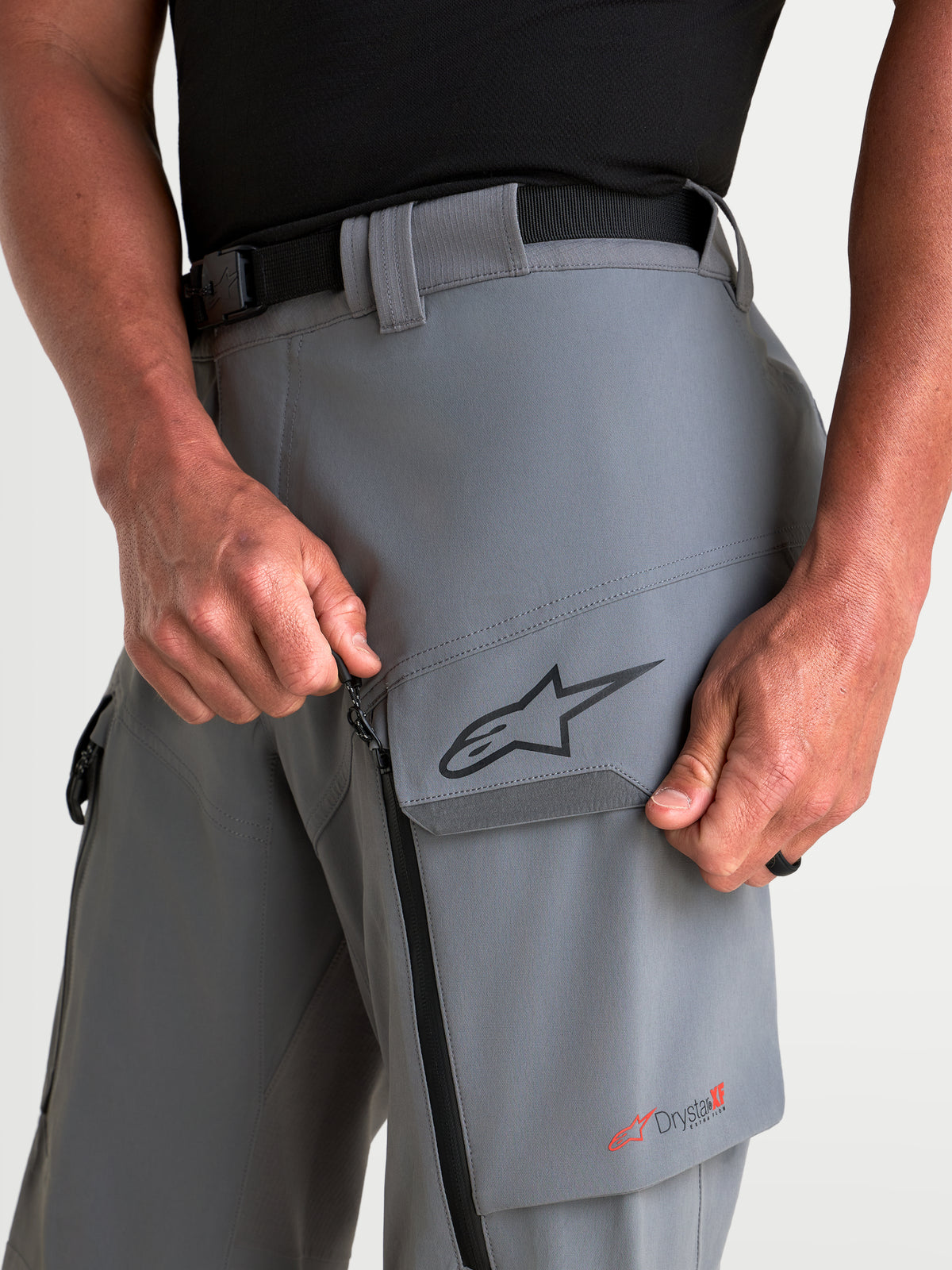 Alpinestars Maxdura Drystar XF Laminated Pantalons, pantalon de moto adventure pour homme gris foncé, vue rapprochée d'une poche cargo sur la cuisse avec ventilation zippée et marquage Drystar XF