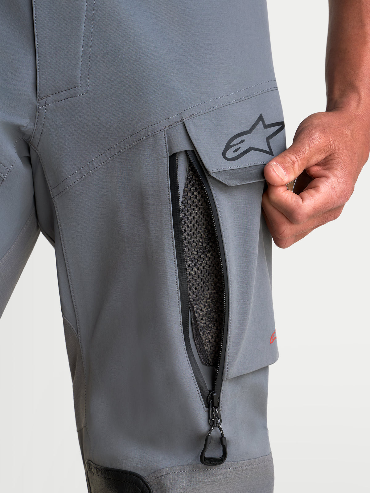 Alpinestars Maxdura Drystar XF Laminated Pantalons, pantalon de moto adventure gris et noir, vue rapprochée de la ventilation zippée sur la cuisse et de la poche cargo avec le logo A-star