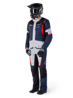 Pantalon imperméable Alpinestars St-1, pantalon Adventure Touring, bleu foncé, noir et rouge vif, porté avec une veste de touring assortie, un casque noir, des gants et des bottes, avec des panneaux gris clair, des accents rouges et le logo Alpinestars, conçu pour la conduite par tous les temps