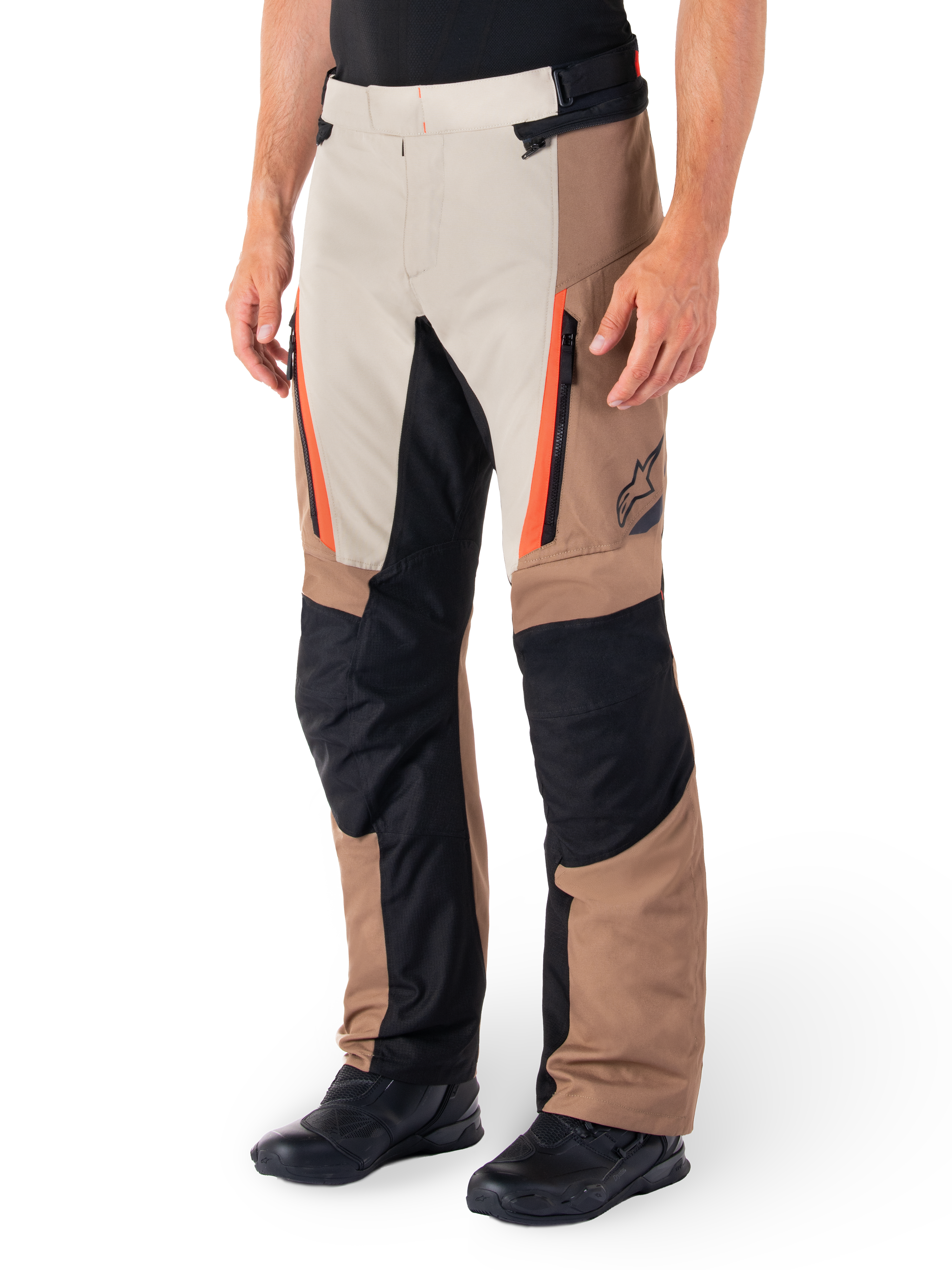 Alpinestars ST-1 Waterproof Pants, Adventure Touring Pants, Dark Khaki Sand Black and Red Fluo, featuring zippered front pockets and black reinforced panels on the knees and inner legs, worn with black riding shoes, ergonomic textile design for all-weather riding