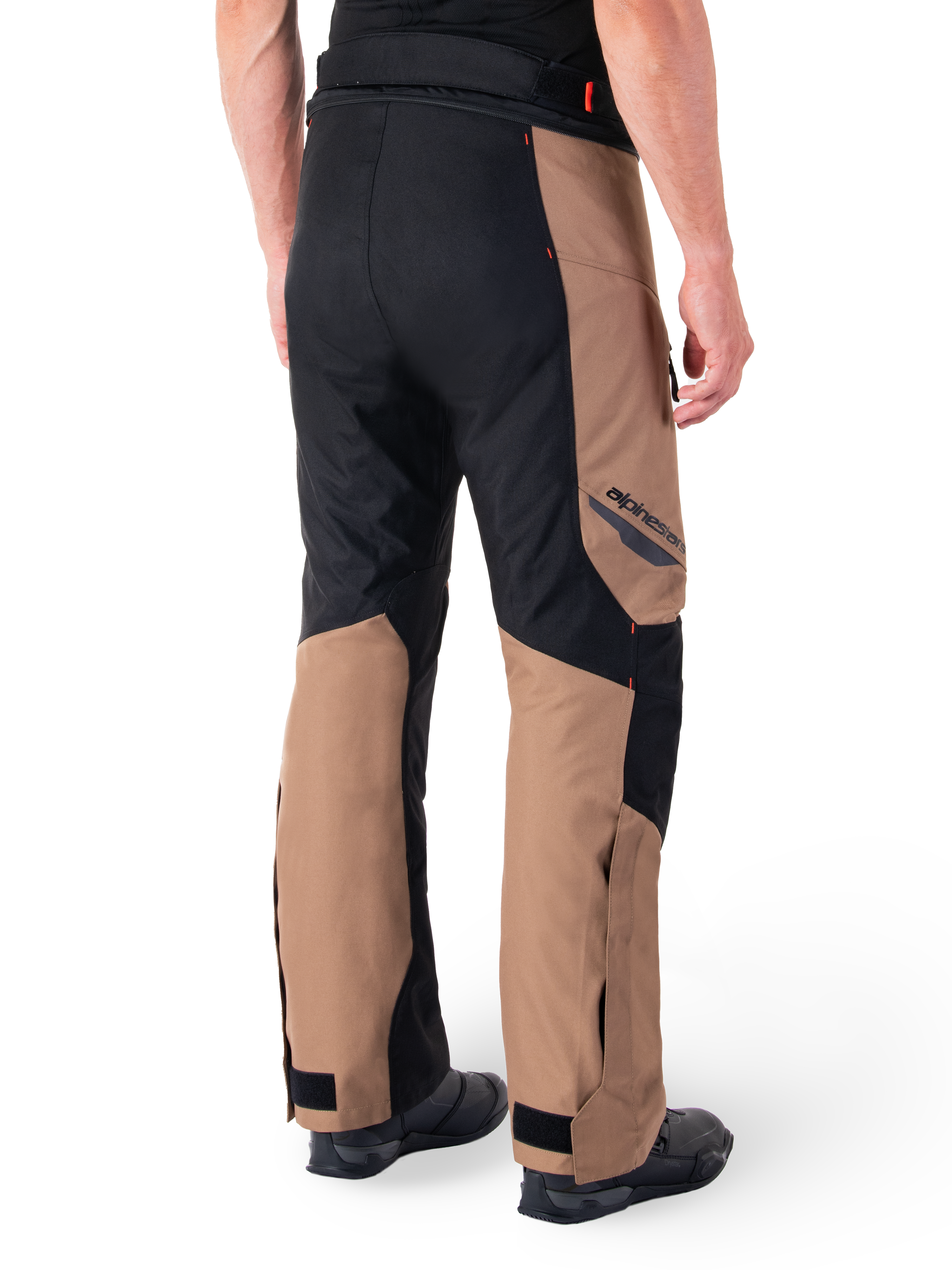 Alpinestars St-1 Waterproof Pants, Motorcycle Touring Pants, Dark Khaki Sand and Black with Red Fluo accents, rear three-quarter view, featuring Alpinestars branding on the thigh and adjustable ankle straps, worn with black boots.