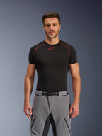 Pantalon Alpinestars Andes Pro Drystar® XF, pantalon de moto aventure, gris foncé et noir, porté par un mannequin homme avec une couche de base technique noire, doté d'une boucle de taille magnétique, d'une construction textile durable et du marquage Drystar® XF pour le touring toutes saisons.
