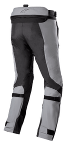 Pantalon Alpinestars Bogotá Pro Drystar® 3 Saisons, pantalon de moto Adventure Touring, gris foncé et gris clair, vue arrière avec sangles de réglage aux mollets et aux chevilles, fermeture éclair de raccordement à la taille et panneaux textiles en ripstop résistant.