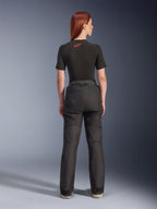 Vue arrière d'un mannequin portant le pantalon Alpinestars Stella Andes V4 Drystar® noir, associé à une sous-couche noire à manches courtes ornée d'un logo Alpinestars rouge, équipement de moto d'aventure-touring avec une construction textile durable.