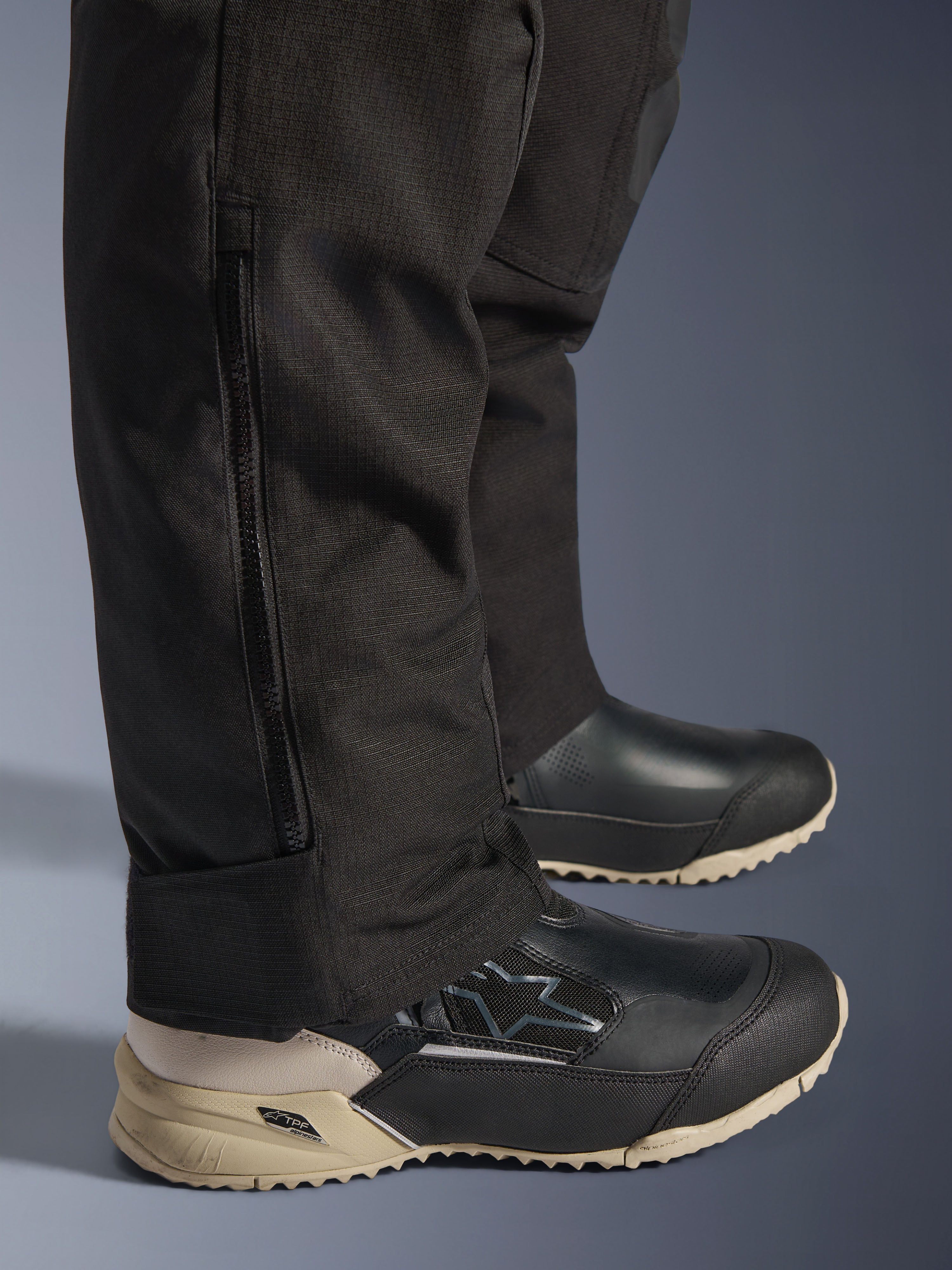 Pantalon Alpinestars Stella Andes V4 Drystar®, détail du bas de la jambe noir montrant une fermeture éclair latérale verticale pour l'ajustement des bottes, construction en tissu textile durable, équipement de moto d'aventure pour femme