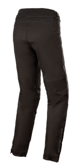 Pantalon imperméable Alpinestars Stella AST-1 V2, pantalon de moto textile pour femme, noir, vue de trois-quarts arrière montrant la fermeture éclair de connexion à la taille, les jambes pré-courbées et le logo réfléchissant Alpinestars sur le bas du mollet