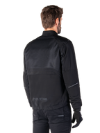 Alpinestars Mootant Waterproof Parka, Black motorcycle jacket, rear view, featuring mesh upper panels and MO.ST.EQ. Moto Streetwear Equipment branding, urban contemporary design for road riding