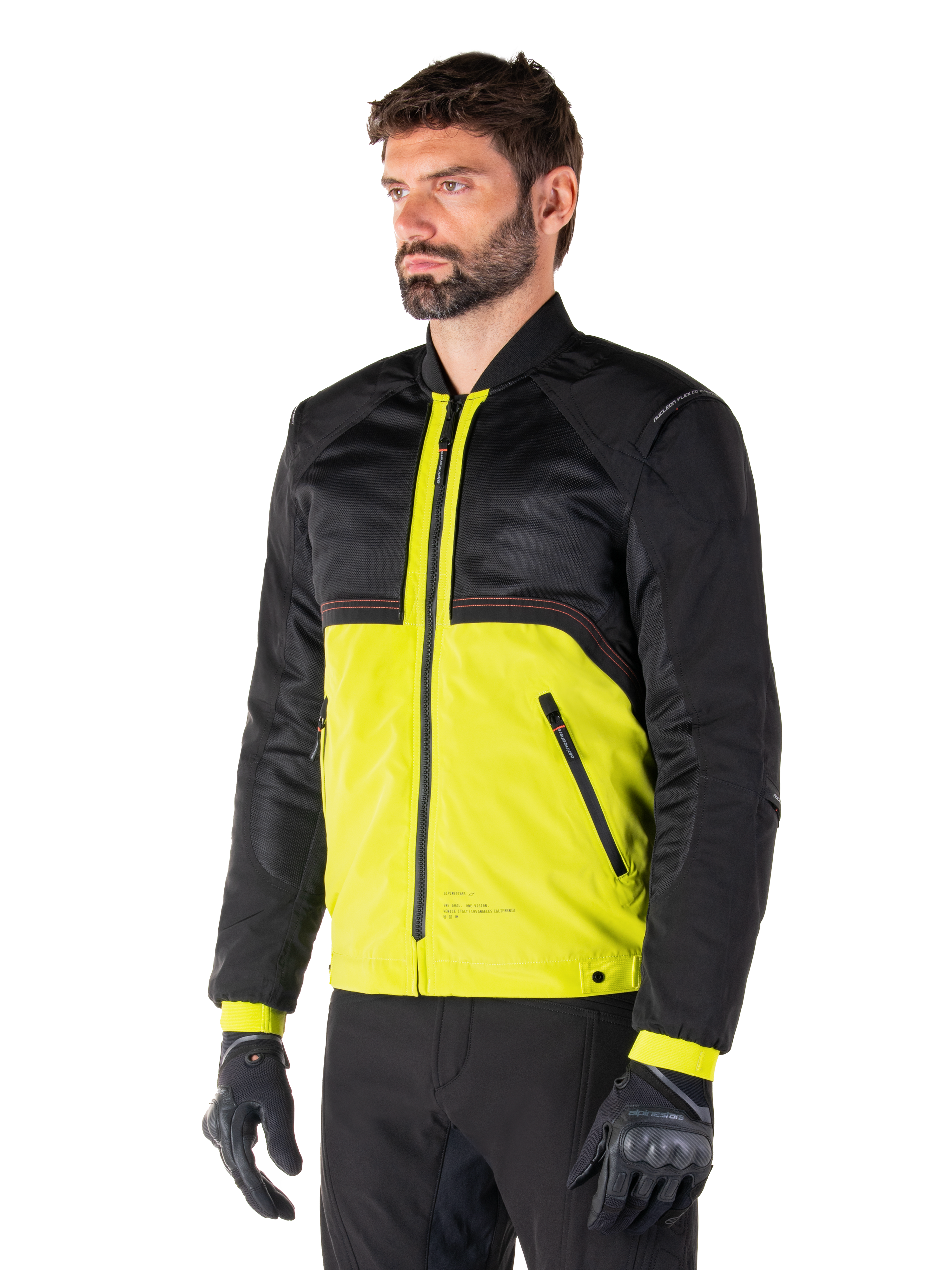 Parka imperméable Alpinestars Mootant en Lime Punch Black, veste de moto modulaire avec une partie supérieure en maille noire et une partie inférieure vert lime vif, portée par un pilote avec des gants et un pantalon noirs, style urbain contemporain