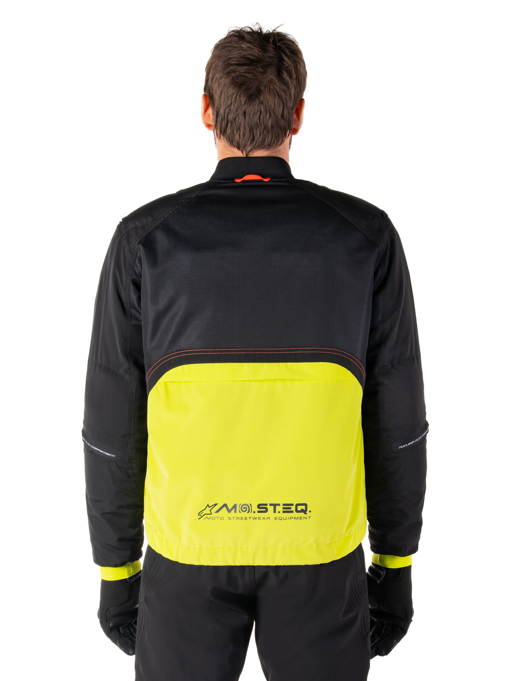 Parka imperméable Alpinestars Mootant, veste de moto, Lime Punch et noir, vue de dos présentant une partie supérieure en mesh noir pour la ventilation et une partie inférieure lime avec le logo MO.ST.EQ., portée avec un pantalon et des gants noirs