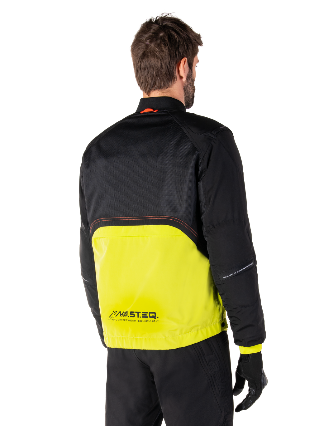 Parka imperméable Alpinestars Mootant, veste de moto, lime punch et noir, vue arrière montrant la partie supérieure en maille noire et la partie inférieure en vert lime éclatant, avec marquage MO.ST.EQ., portée avec un pantalon de moto et des gants noirs