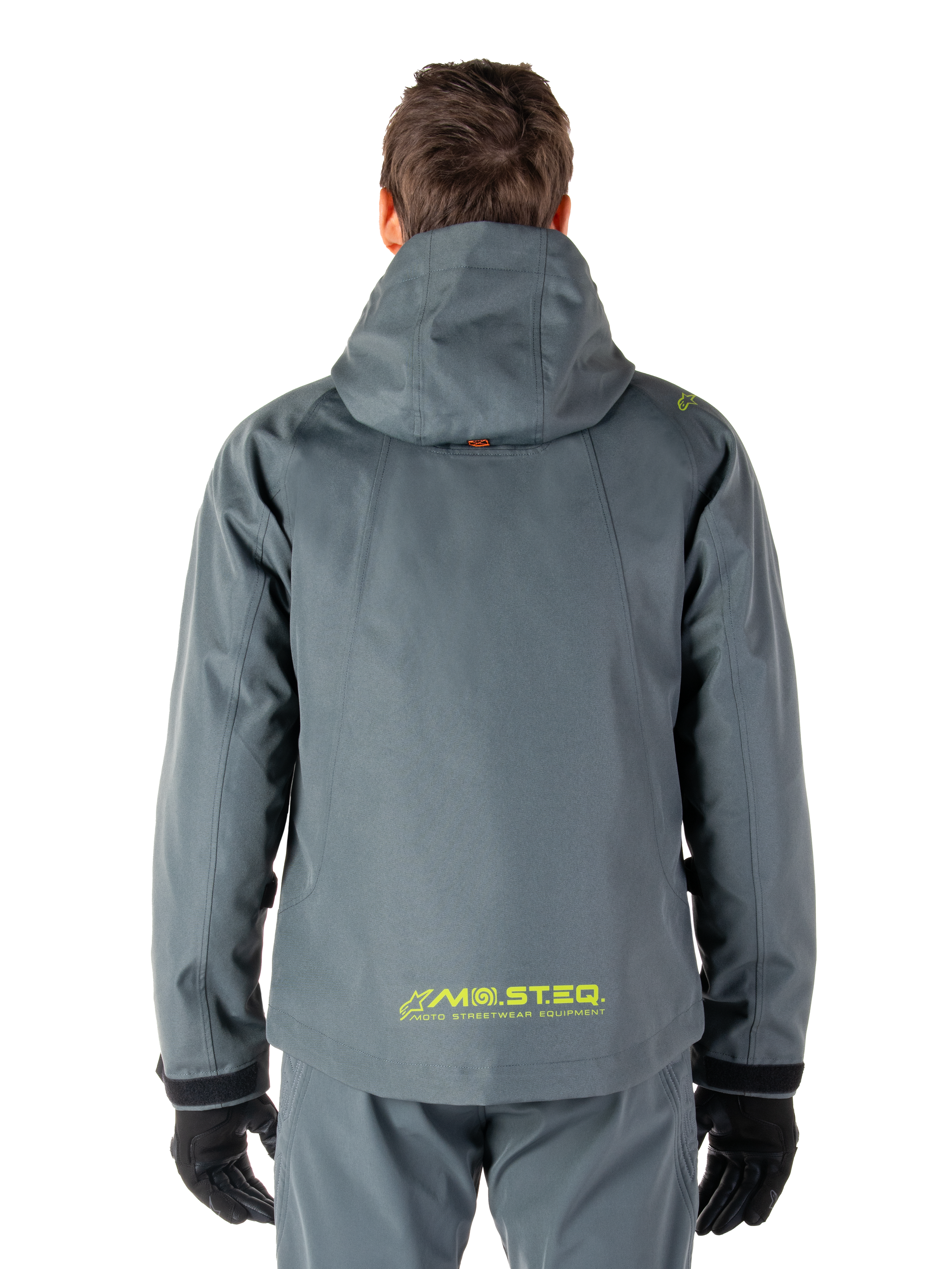 Parka imperméable Alpinestars Morush, veste de moto, gris urbain, vue arrière montrant la capuche et le logo MO.ST.EQ. jaune en bas du dos, équipement de moto moderne inspiré du streetwear urbain