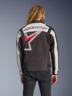 Veste Alpinestars Axton, veste de moto, noir, blanc cassé et rouge vif, vue arrière présentant un grand logo étoile enveloppant et un mot-symbole, design d'inspiration racing vintage avec panneaux accordéon aux épaules et ajusteurs à la taille