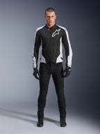 Veste Alpinestars Viper Air V4, veste de moto noire et blanche avec un grand logo blanc sur la poitrine, portée par un mannequin homme avec un pantalon noir et des gants, dotée de panneaux en maille pour la ventilation, vêtement de route sportif