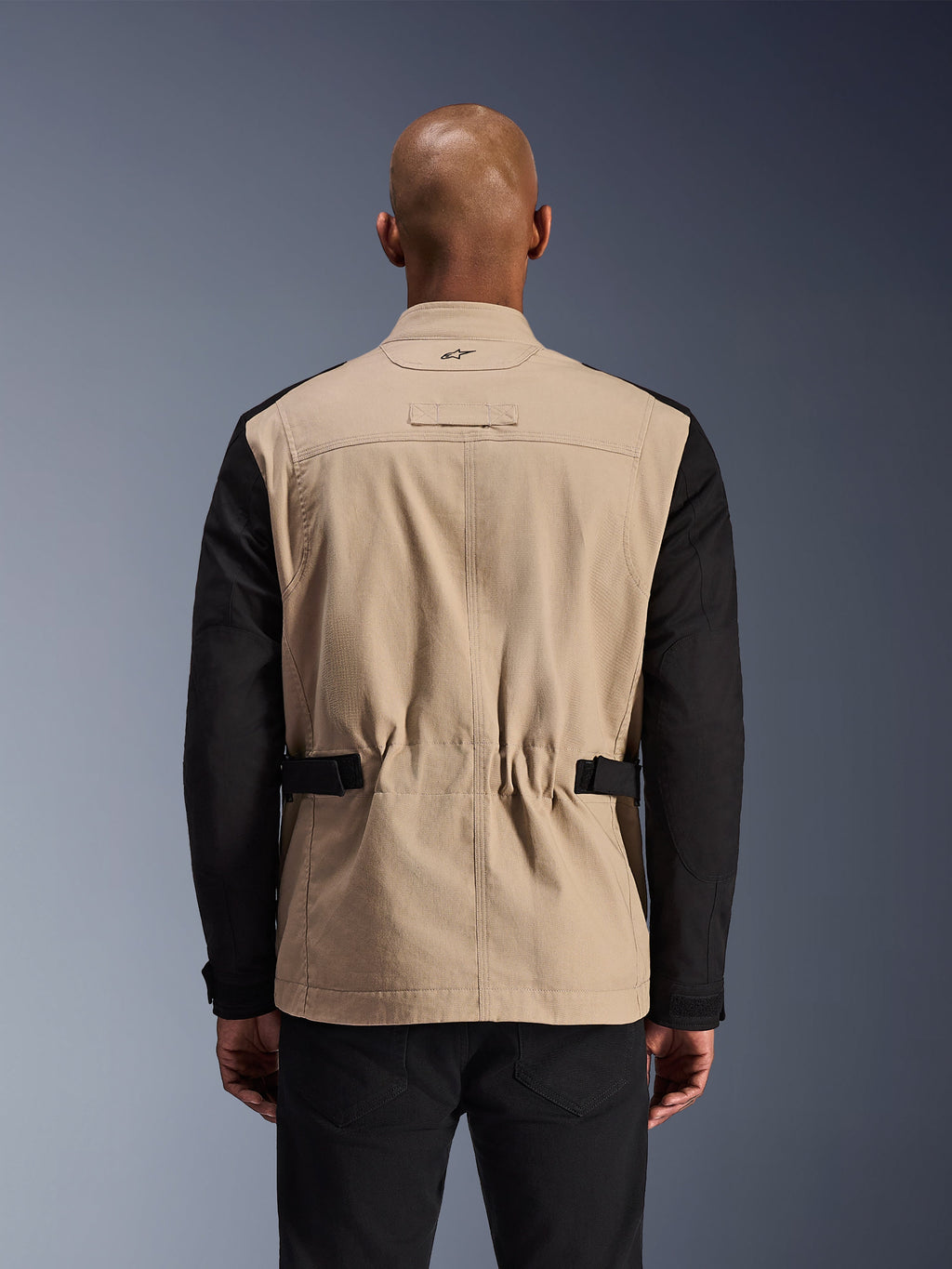 Alpinestars Dice Jacket, Urban Motorcycle Jacket, Aluminum and Black, back view on a model, featuring pleated shoulders for mobility, adjustable waist straps, and a rugged polycotton twill construction.