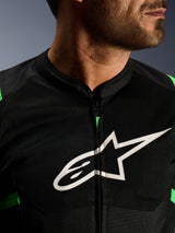 Gros plan de la veste Alpinestars T-SPS Air V2, noir et vert fluo, avec panneaux en maille technique respirante, fermeture éclair centrale et logo étoile Alpinestars blanc sur la poitrine, équipement moto haute performance