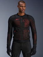 Veste Alpinestars Troop-Air Pro, veste de moto technique blindée, noir et rouge fluo, dotée de tirettes de fermeture éclair rouges et du logo Alpinestars, panneaux en maille respirante avec sous-couche rouge, portée avec pantalon et gants de moto noirs assortis