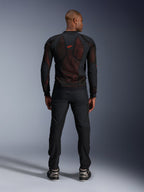 Veste Alpinestars Troop-Air Pro en Noir Rouge Fluo, vue arrière sur mannequin, veste technique en mesh blindé avec panneaux respirants, logo rouge en haut du dos, portée avec un pantalon noir et des baskets, équipement de moto urbain