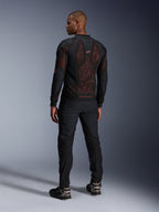 Veste Alpinestars Troop-Air Pro en Noir Rouge Fluo, vue de dos sur un mannequin, dotée d'un large panneau dorsal en mesh technique 2D avec intérieur rouge visible, associée à un pantalon de moto technique noir et des bottes noir et gris, design urbain moderne.