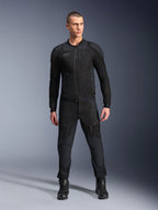 Veste Alpinestars Troop-Air Pro, veste de moto technique blindée noire, dotée de panneaux en mesh et de fermetures éclair à l'avant, portée avec un pantalon noir assorti et des bottes de moto, équipement de route urbain haut de gamme