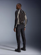 Veste Alpinestars Troop-Air vue de dos, coloris noir, gris cendre et rouge vif, construction technique en maille pour la ventilation, associée à un pantalon de moto noir et des bottes de pilotage, style urbain contemporain