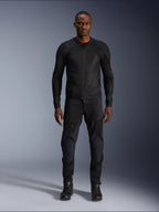 Modèle masculin portant la veste Alpinestars Troop-Air en coloris Black Black, veste de moto légère en mesh, associée à un pantalon et des bottes de moto noirs assortis, dotée d'une construction technique en maille 2D pour un flux d'air supérieur.