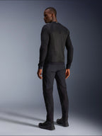 Veste Alpinestars Troop-Air, veste technique de moto aérée noire, vue arrière présentant de larges panneaux en maille pour une ventilation supérieure, portée avec un pantalon noir et des bottes de moto assortis, design urbain contemporain pour la conduite estivale