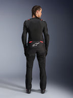 Veste Alpinestars Stella T-SPS Air V2, veste de moto en textile pour femme, noir et rose Diva, vue arrière sur un mannequin aux cheveux tressés, dotée de grands panneaux en mesh pour la ventilation, logo Astars blanc dans le bas du dos, associée à un pantalon de moto noir assorti.