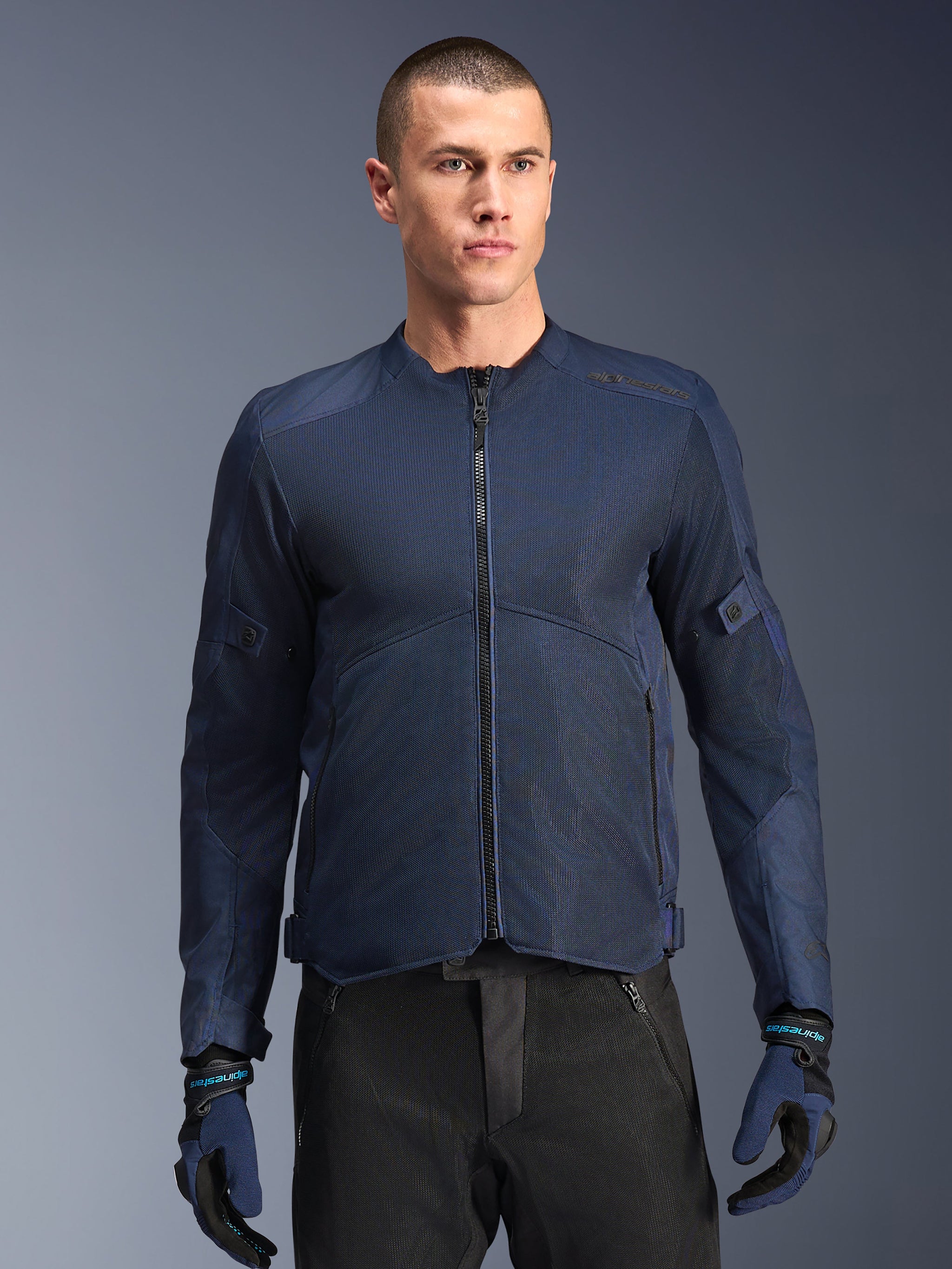Alpinestars C-1 Air Jacket, Blue motorcycle jacket, worn by a male model with black pants and matching blue and black gloves, featuring tech mesh panels for airflow, clean urban design with front zipper and subtle branding
