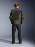 Vue arrière d'un motard portant la veste Alpinestars C-1 Air en kaki et noir, dotée d'un grand panneau arrière en maille technique pour la ventilation, associée à un pantalon de moto noir, équipement de route urbain contemporain
