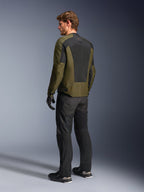 Modèle masculin portant la veste Alpinestars C-1 Air en Khaki, veste de moto urbaine, vue arrière mettant en évidence de larges panneaux en maille noire dans le dos, associée à un pantalon de moto technique et des gants noirs, équipement de moto contemporain pour temps chaud