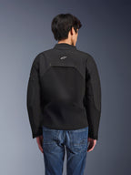 Veste Alpinestars Provoke, veste de moto urbaine, noire, vue arrière montrant le logo Astars blanc et des panneaux techniques en ripstop, portée avec un jean bleu, design contemporain pour les trajets urbains