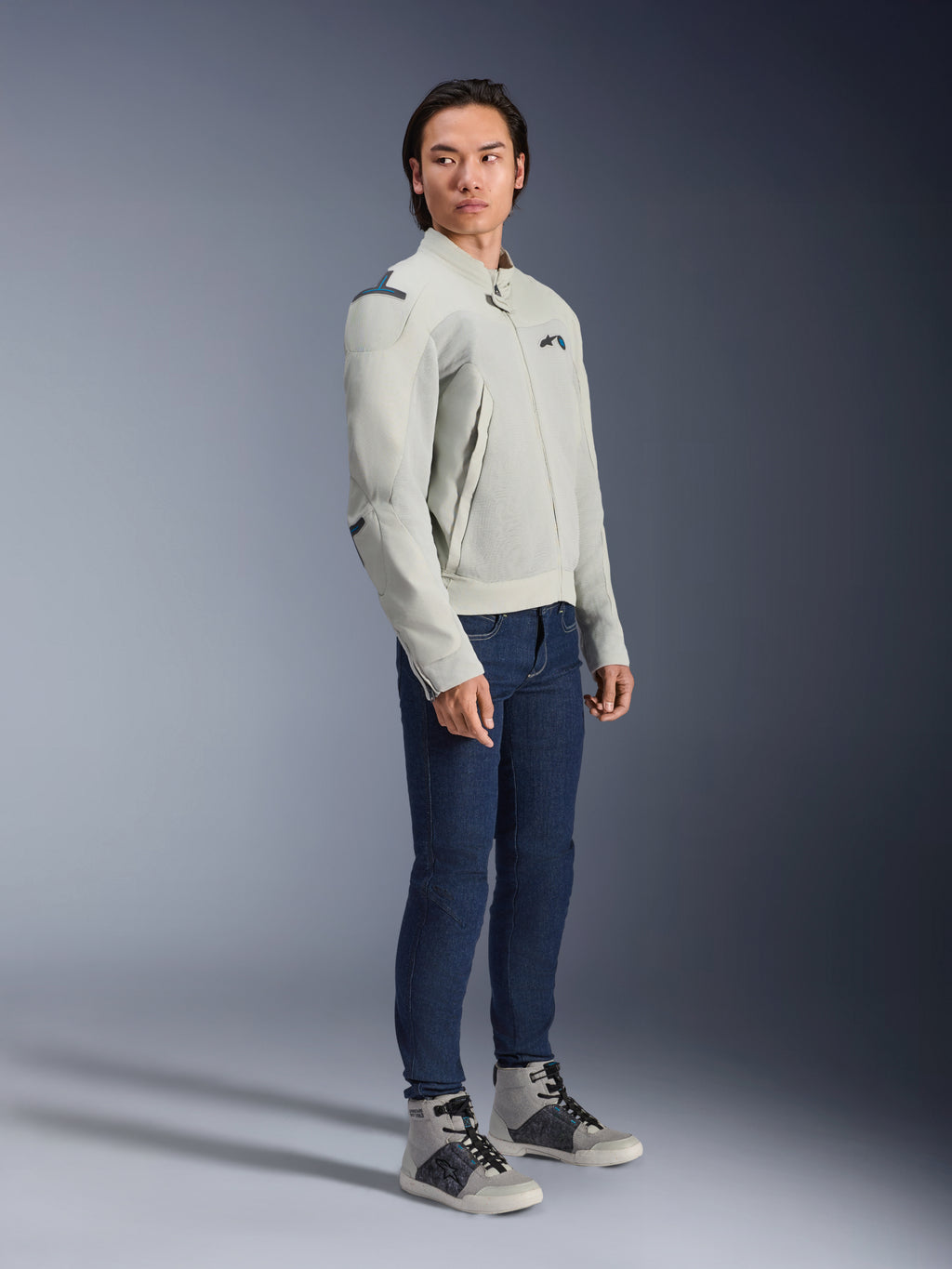 Veste Alpinestars Circal-1 Air en Metal Gray et Methyl Blue, portée par un mannequin avec un jean bleu foncé et des baskets grises, veste de moto urbaine d'été dotée de grands panneaux en maille pour le flux d'air et d'un design minimaliste.